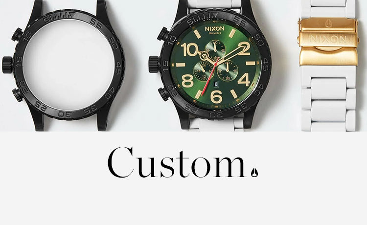 Custom Nixon watch with green face, gold accents, and white band, next to an empty watch case.
