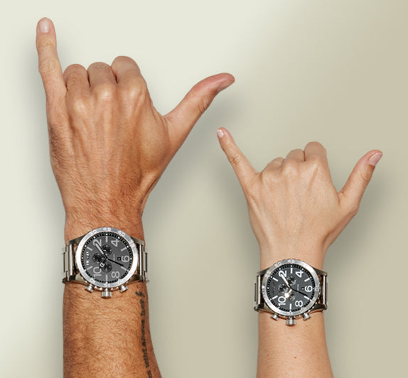 Hands wearing extra large Nixon watches