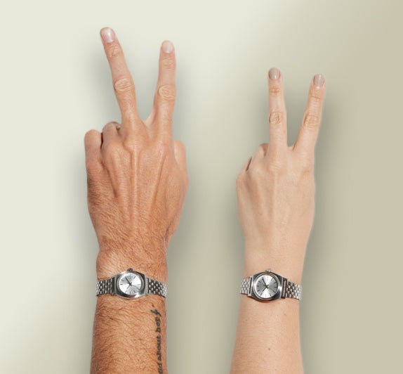 Hands wearing small Nixon watches